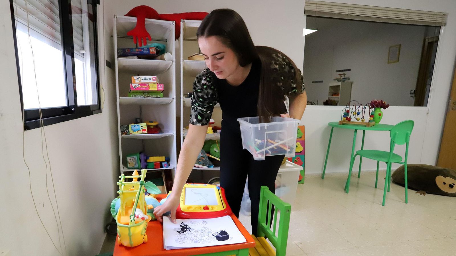 Una de las especialistas del SAVA recoge unos dibujos infantiles.
