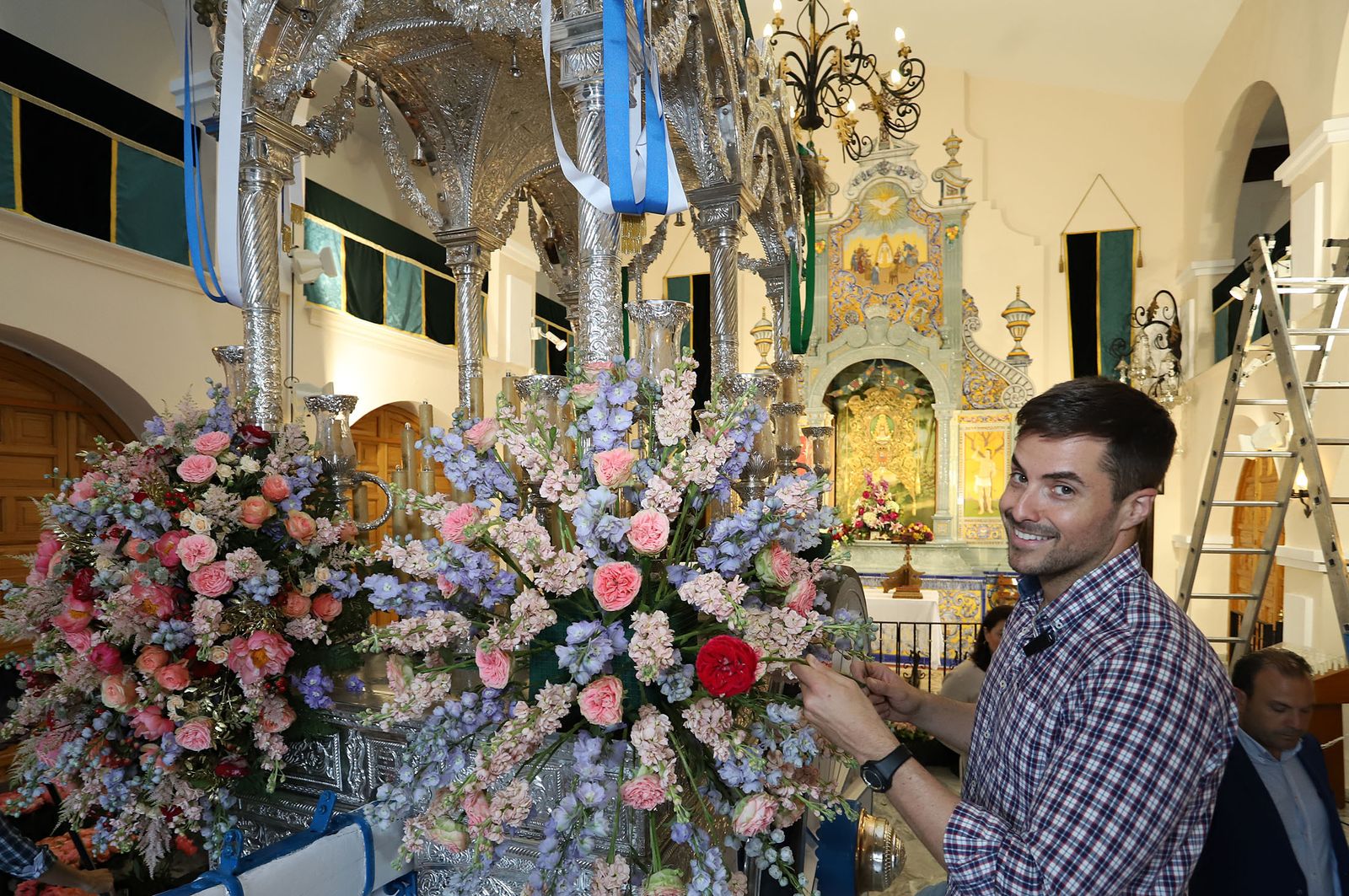 Antonio Rivera coloca las flores color pastel en la carreta de plata de la Hermandad de Huelva.