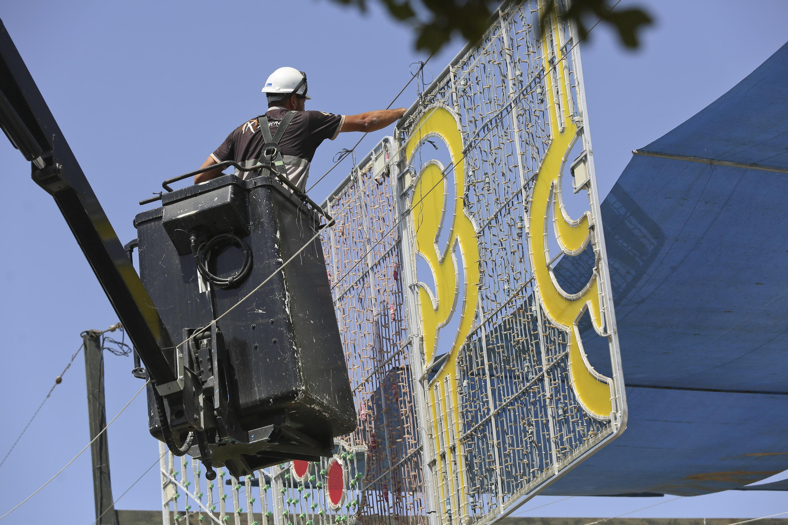 Operarios instalando la iluminación en el Real de la Feria