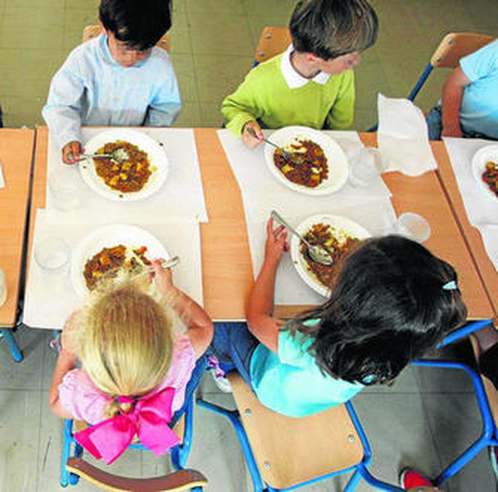 Menores almorzando en un comedor escolar.