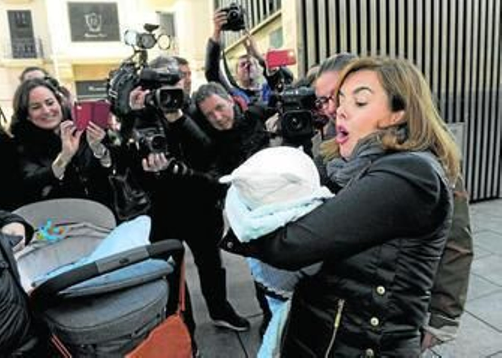 Soraya Sáenz de Santamaría coge en brazos a un bebé durante un paseo, ayer, por las calles de Pamplona.