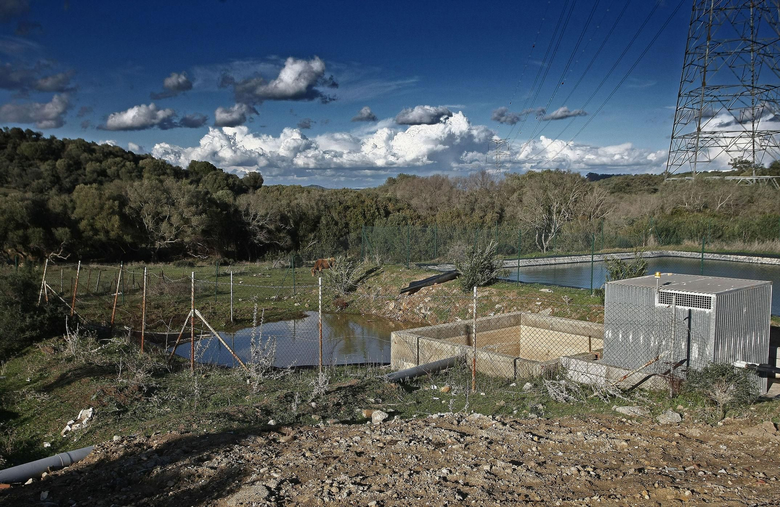 Vertedero de El Cobre, con la balsa de lixiviados y bomba en primer plano.