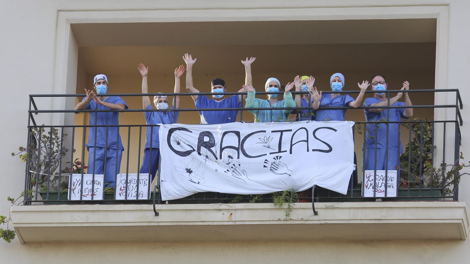 Profesionales agradecen los aplausos desde un balcón del hospital.