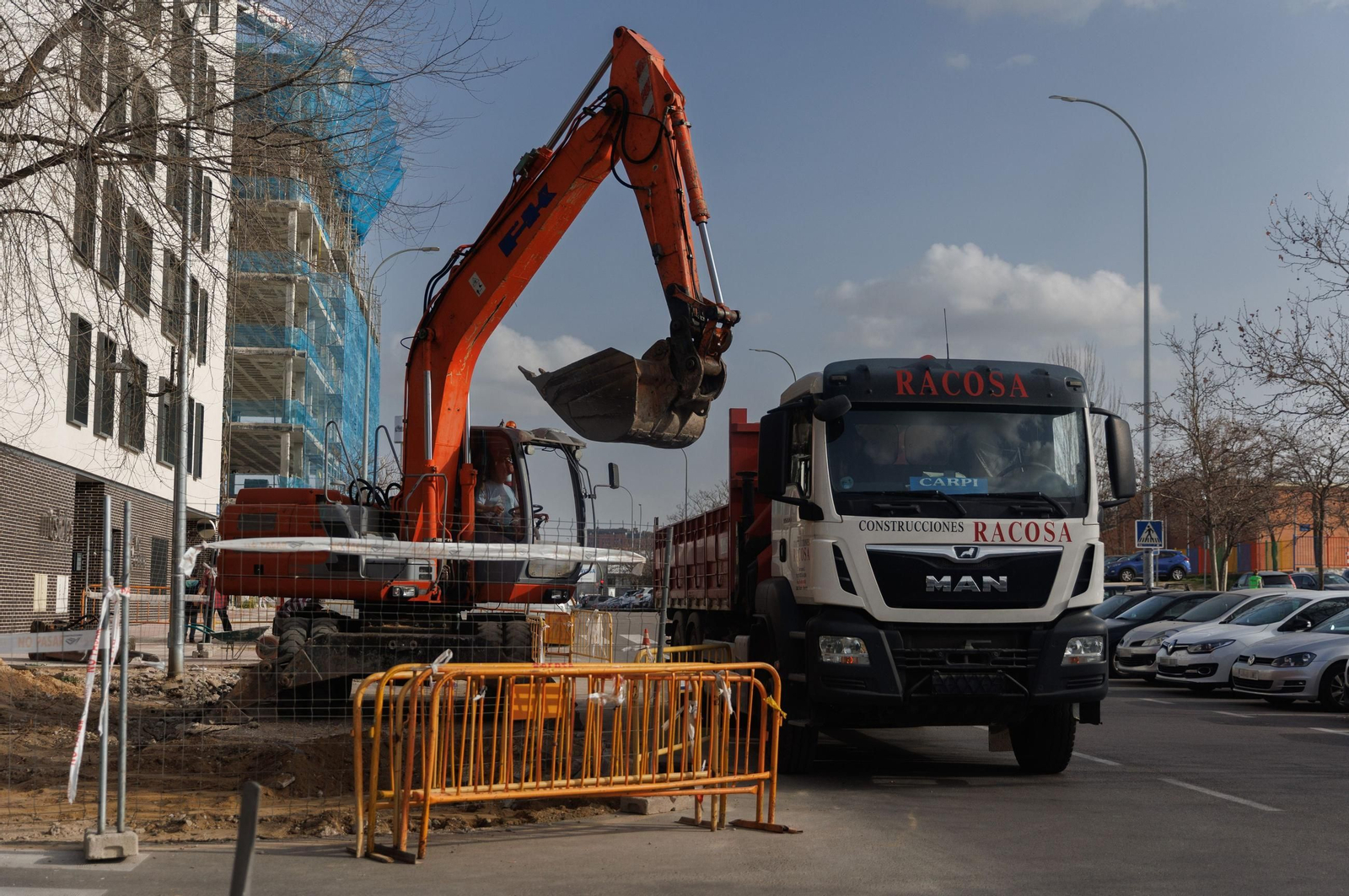 Una excavadora frente a una vivienda en construcción.