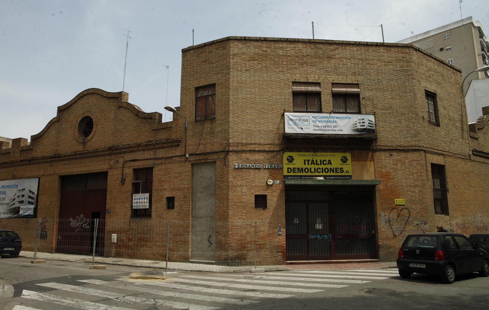 Dos carteles anuncian la inminente demolición de las naves y los nuevos pisos.