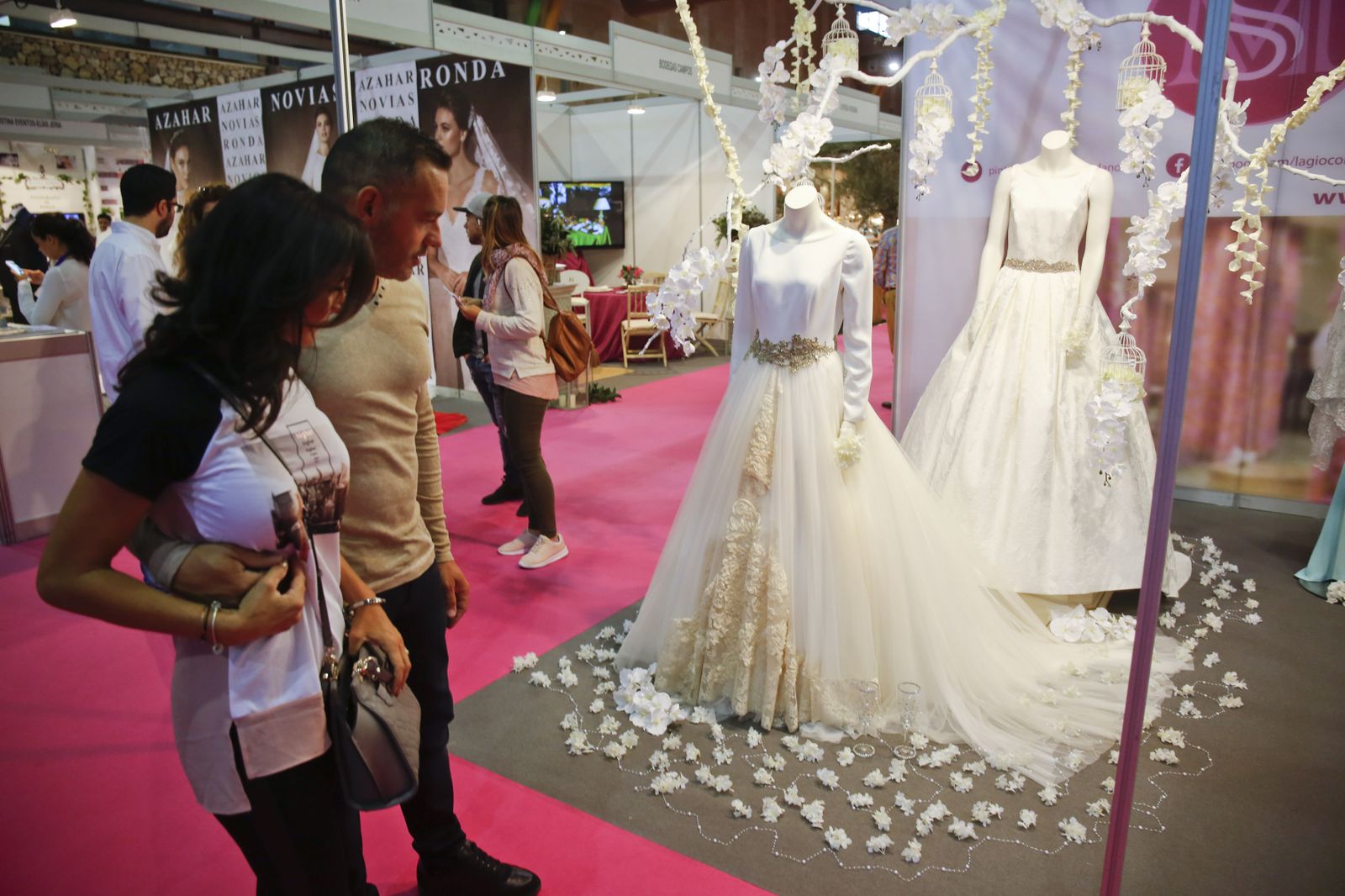 Una pareja observa vestidos de novias en una edición anterior de Celebra Málaga.
