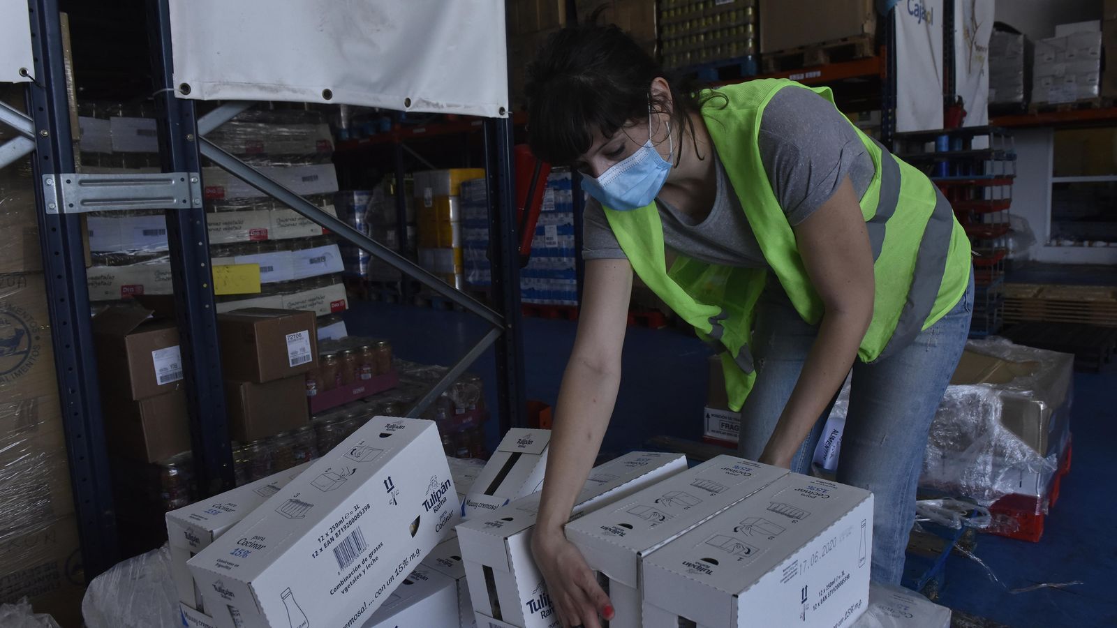 Una joven ordena cajas de alimentos en el almacén.