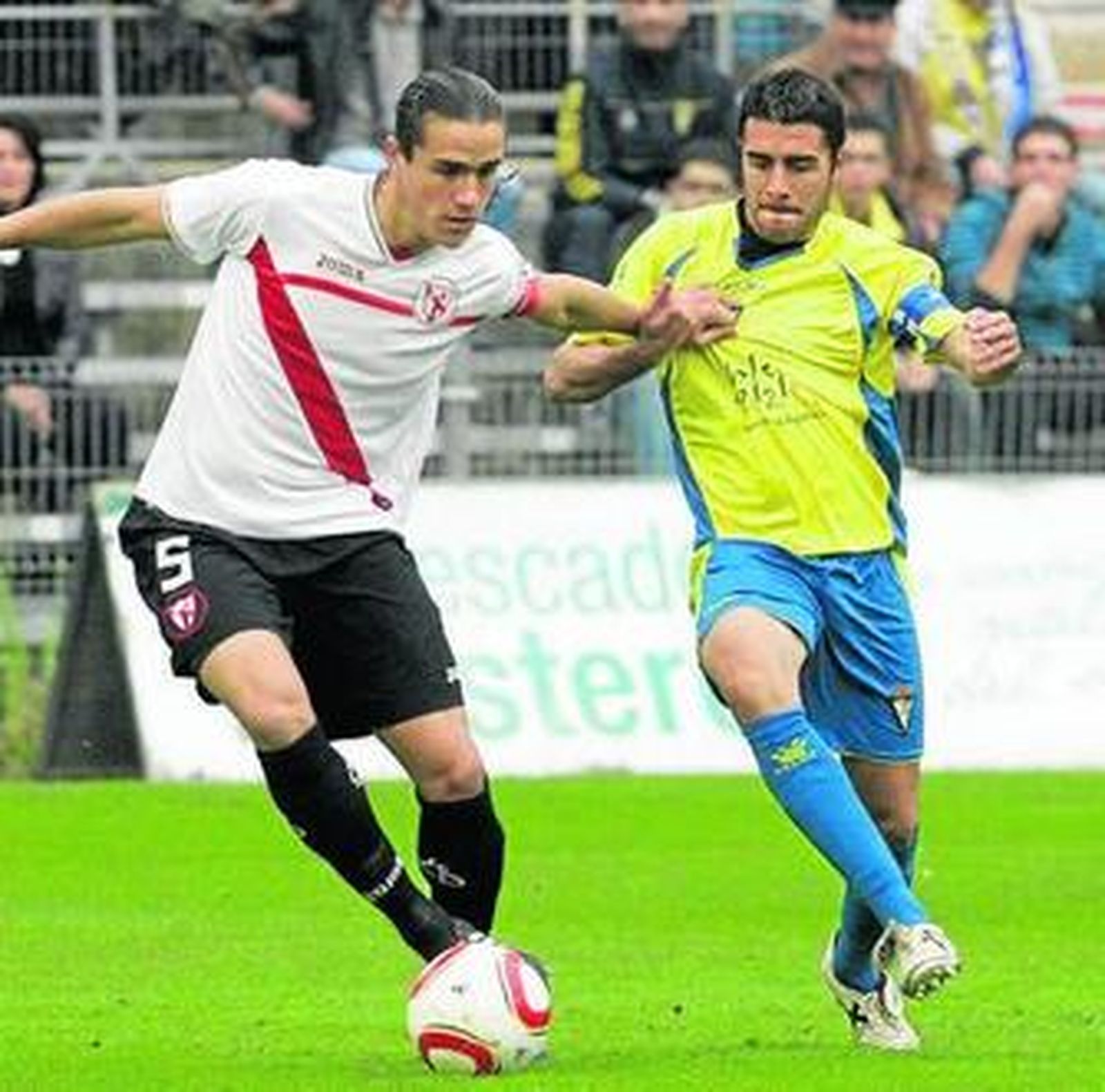 Bernardo, del Sevilla Atlético, agarra a Enrique en el partido de ida.