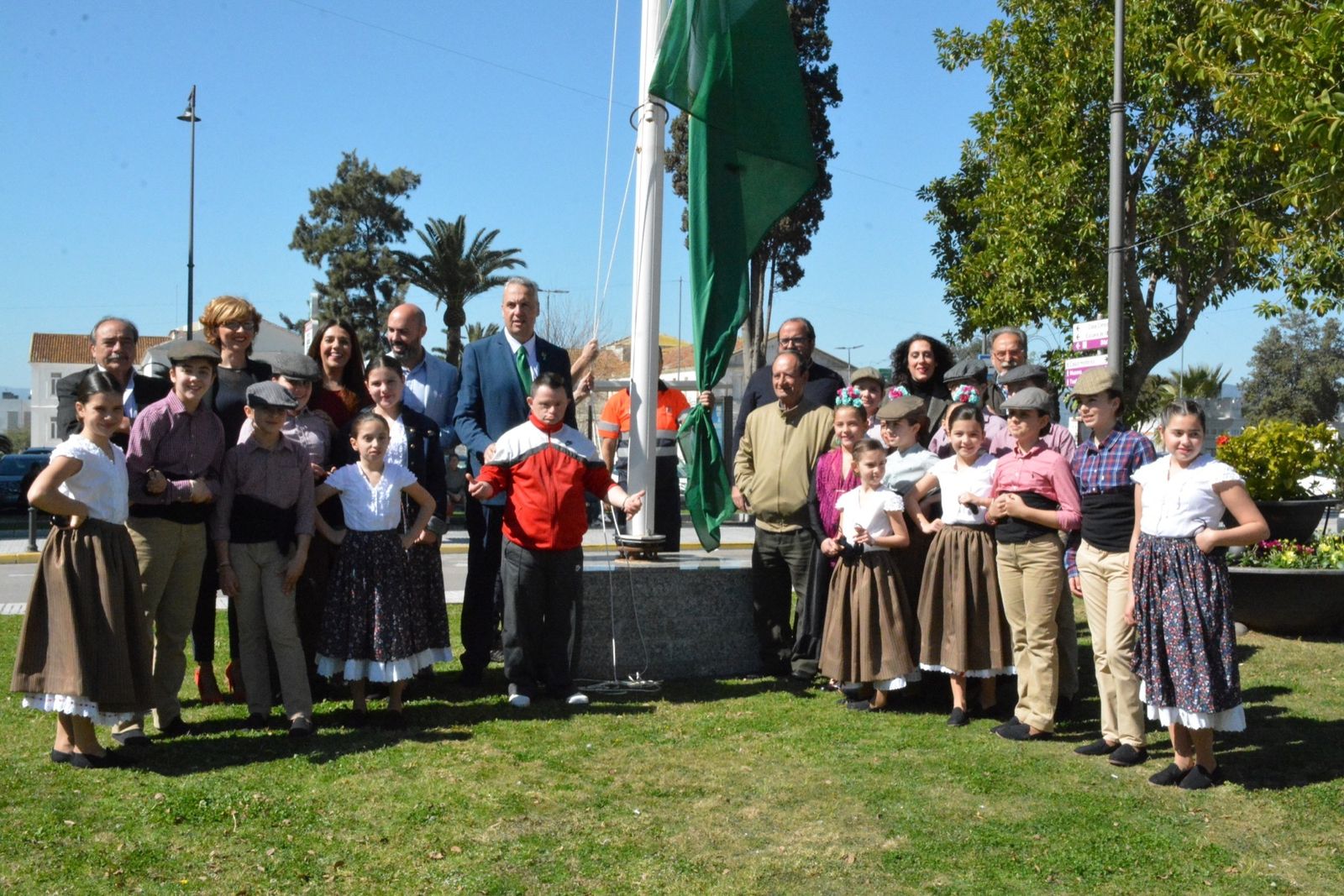 Las autoridades municipales y los artistas invitados para actuar en la Alameda, junto a la bandera.