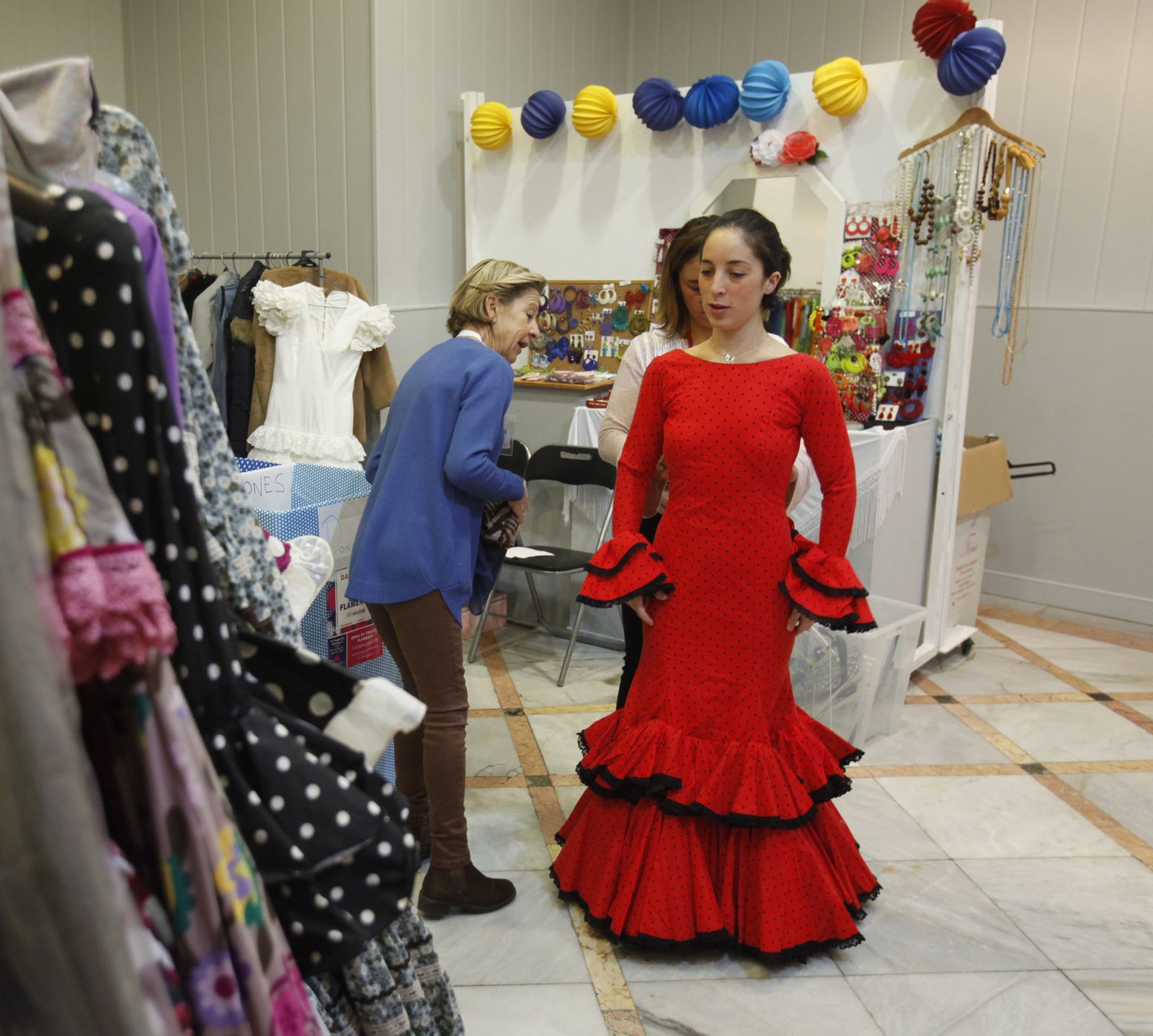 Una joven se prueba un traje de flamenca en el Mercadillo de Red Madre.