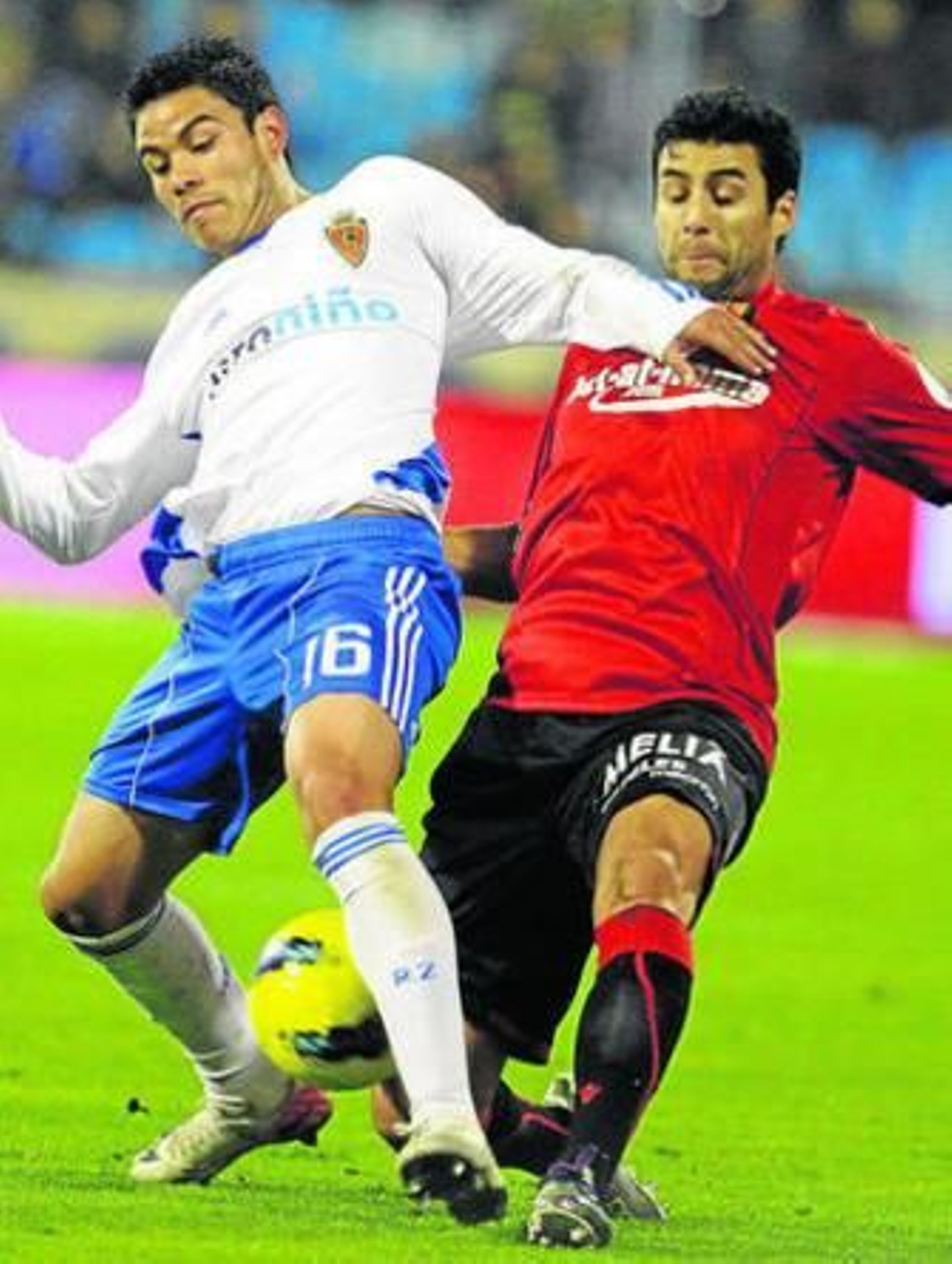 El zaragocista Barrera (i.) recibe la entrada de Cáceres, del Mallorca.