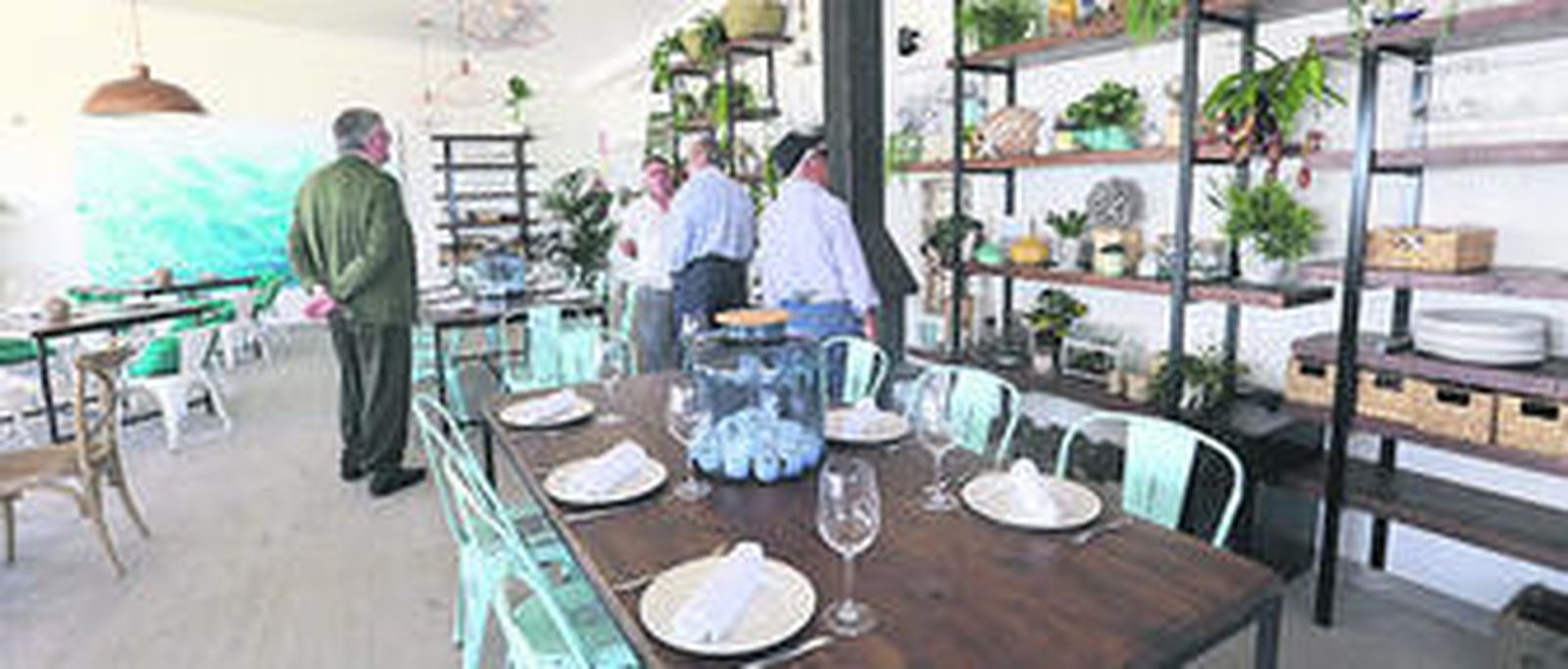 1. Una vista de la parte frontal del nuevo edificio con la entrada al nuevo restaurante de la Casa del Farero, que ayer abrió sus puertas al público. 2. Numerosas personas visitaron las nuevas instalaciones situadas en un lateral del poblado de Sancti Petri.  3. El alcalde de Chiclana y el vicepresidente de la Junta de Andalucía conversan sobre una antigua foto con cientos de anclas que formará parte del centro de interpretación  4. Aspecto que presenta el interior de la nueva edificación en la que se sitúa el novedoso establecimiento hostelero. FOTOS: Sonia Ramos