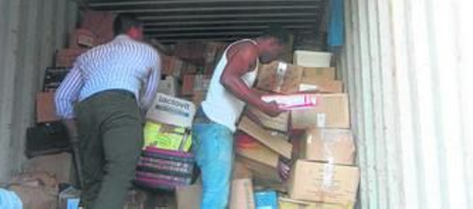 Voluntarios cargan las cajas con libros para su envío a Guinea Ecuatorial.