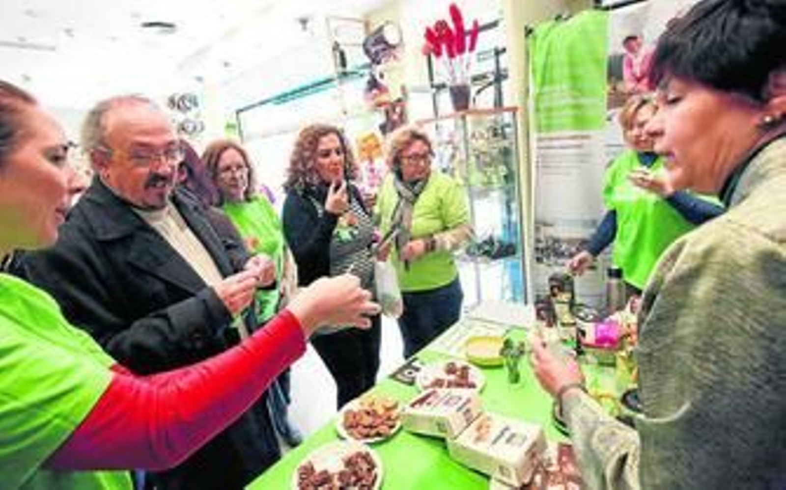 Voluntarias informan de la campaña mientras ofrecen una taza de café acompañada de un dulce.