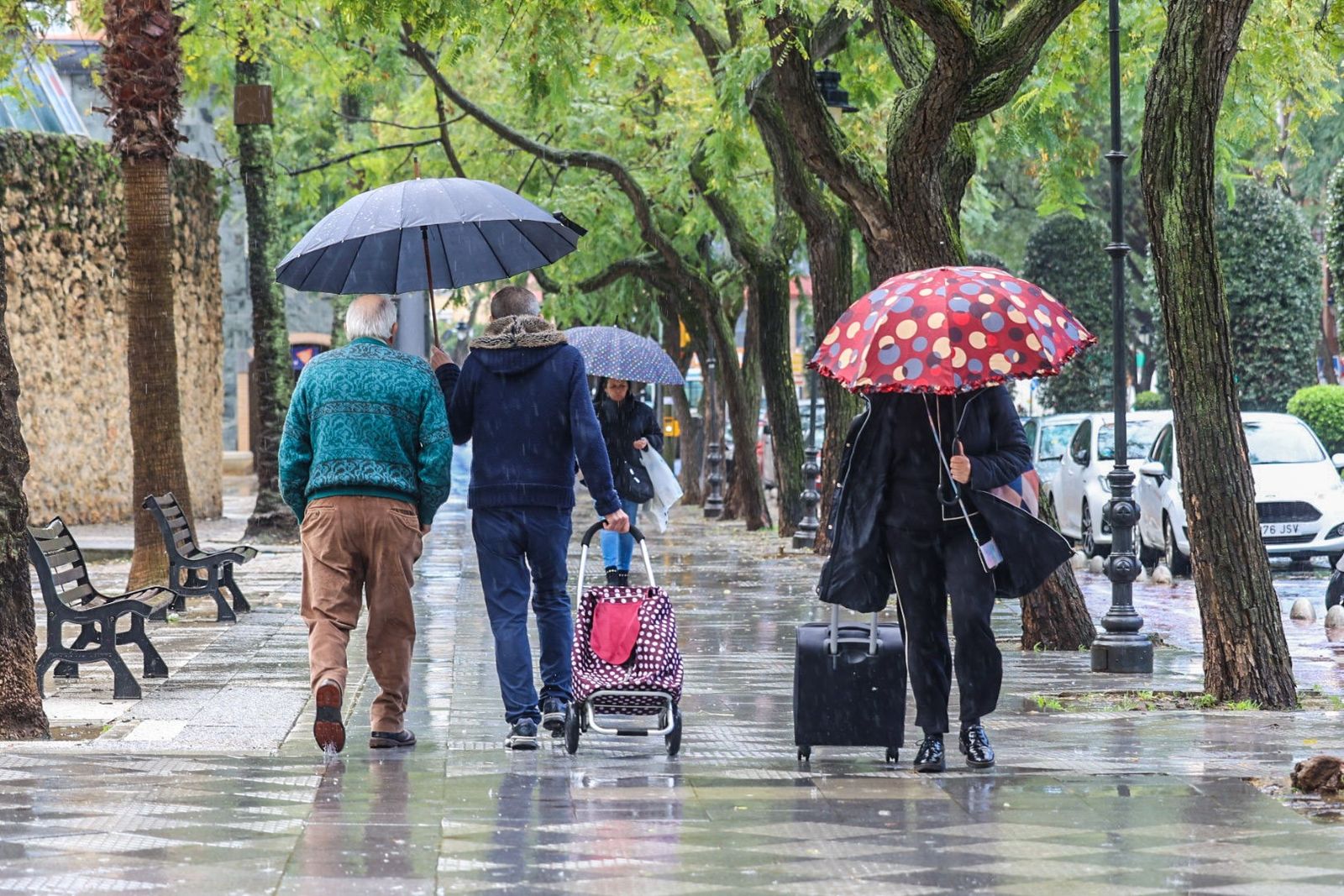 Onubenses bajo la lluvia esta semana en Huelva.