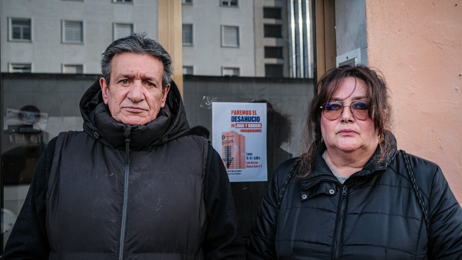 Juan Antonio y Marisol, ante el portal de su casa, con un cartel contra su desahucio.