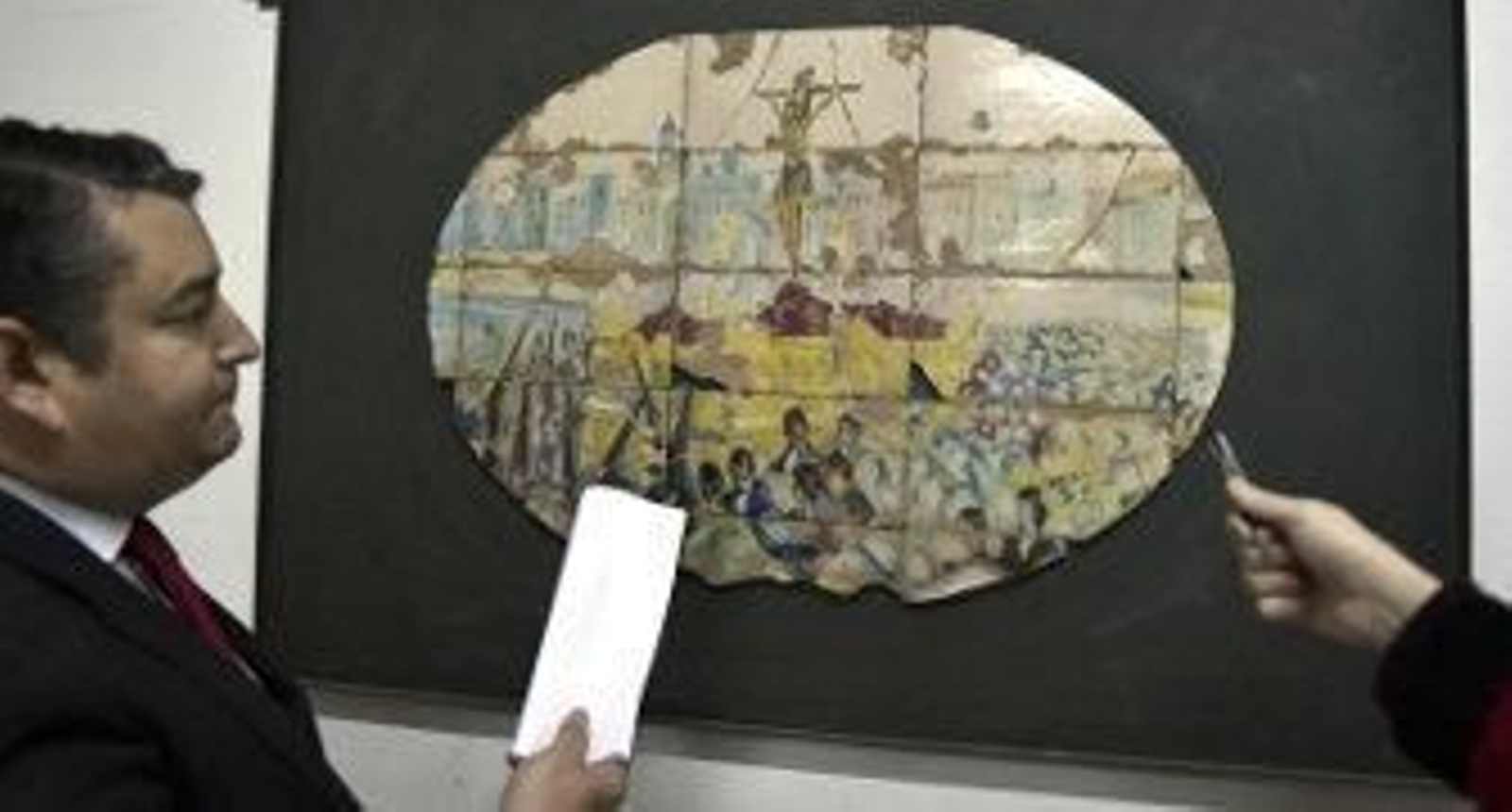 Sanz señala uno de los azulejos del banco de Sevilla, con el paso del Cachorro, que se sustituyó por una réplica. / Juan Carlos Vázquez