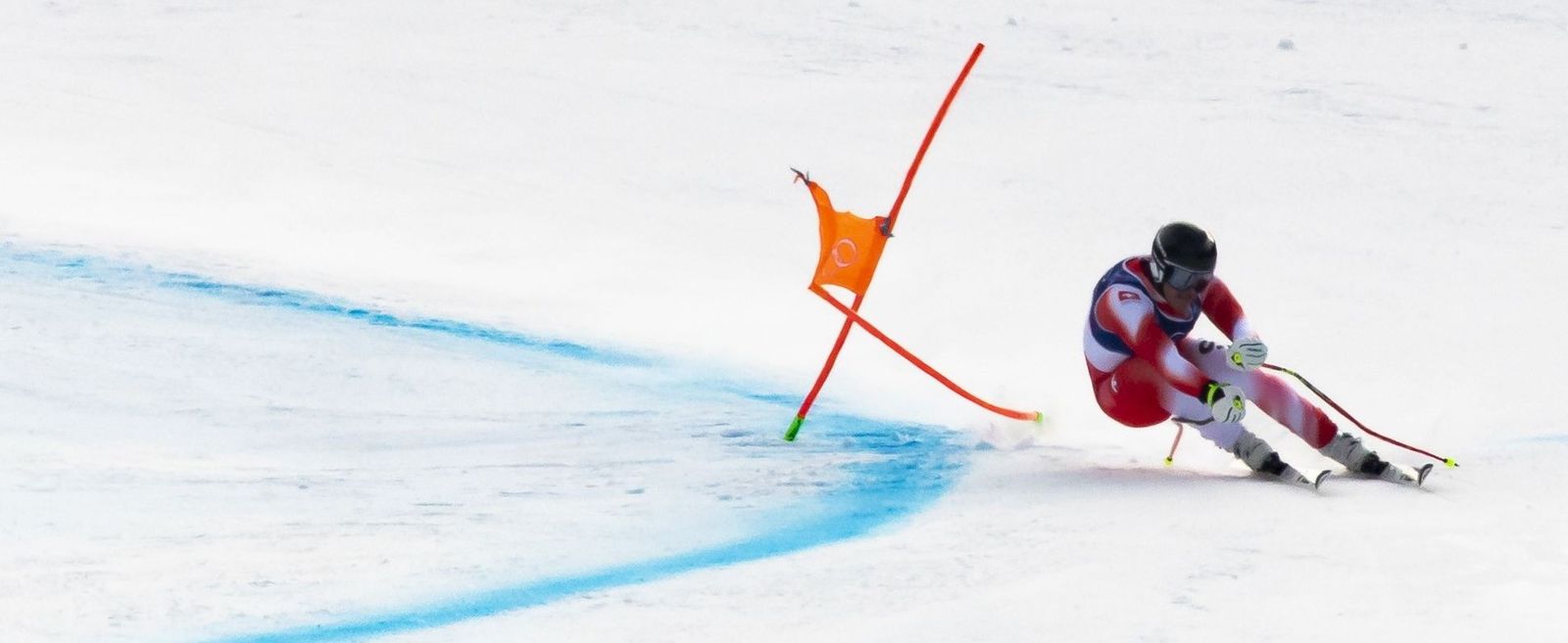 Franjo von Allmen traza una curva durante su vertiginoso descenso en los Juegos Olímpicos.