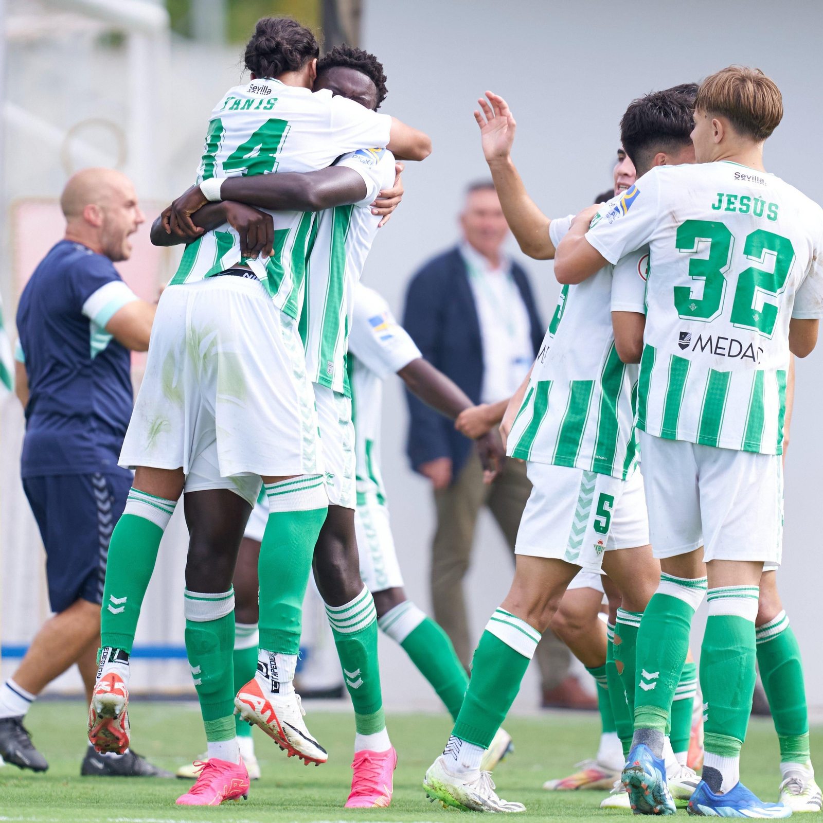 Mawuli, autor del primer tanto del filial verdiblanco, se abraza con Yanis mientras el resto de compañeros también se disponen a felicitarlo.