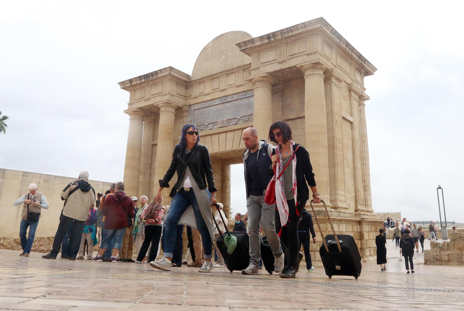 Un grupo de turistas pasa junto a la Puerta del Puente.