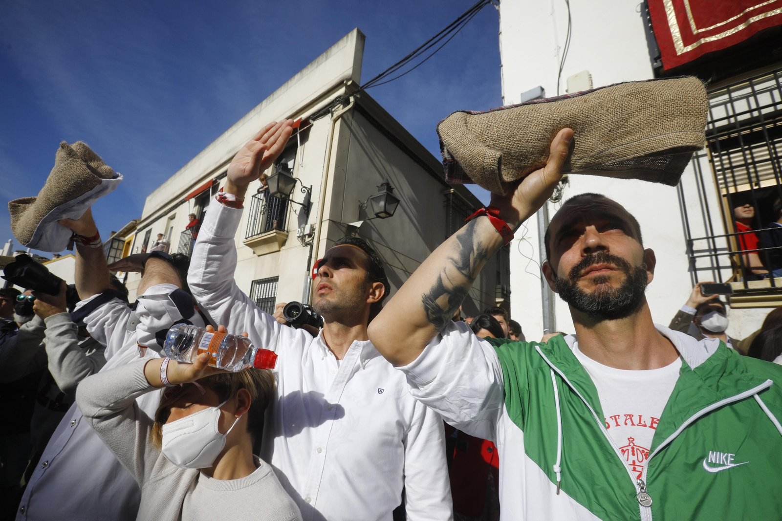 Varios costaleros se cubren del sol, durante la salida procesional de la Borriquita de 2022. Varios costaleros se cubren del sol, durante la salida procesional de la Borriquita de 2022.