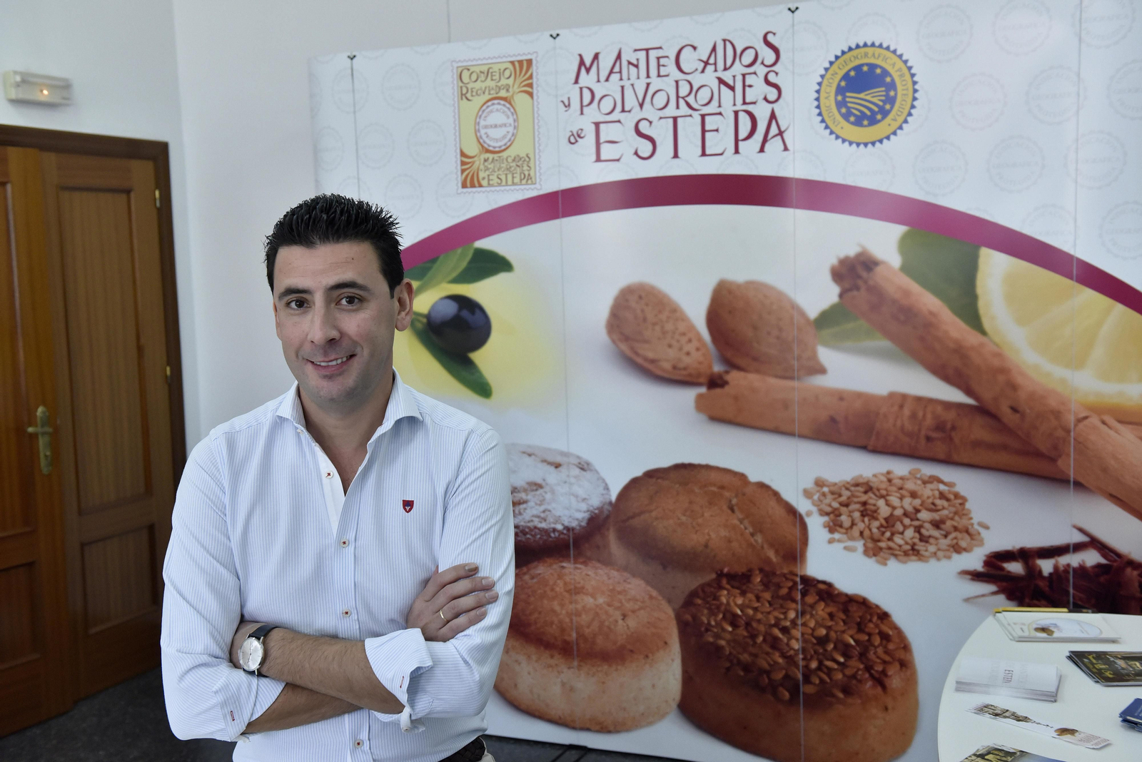 Fernández, ante un cartel en el que se reproducen los sellos que garantizan la 'denominación de origen' Estepa.