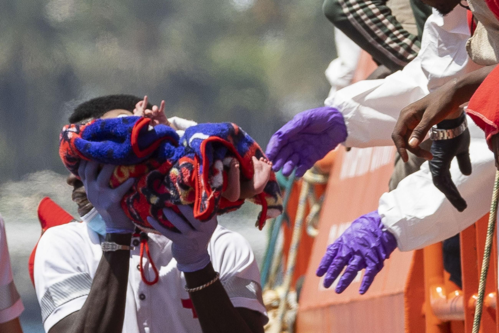 Un bebé que viajaba en la patera rescatada el domingo en Canarias, en el desembargo en el puerto de Puerto de Arguineguín.