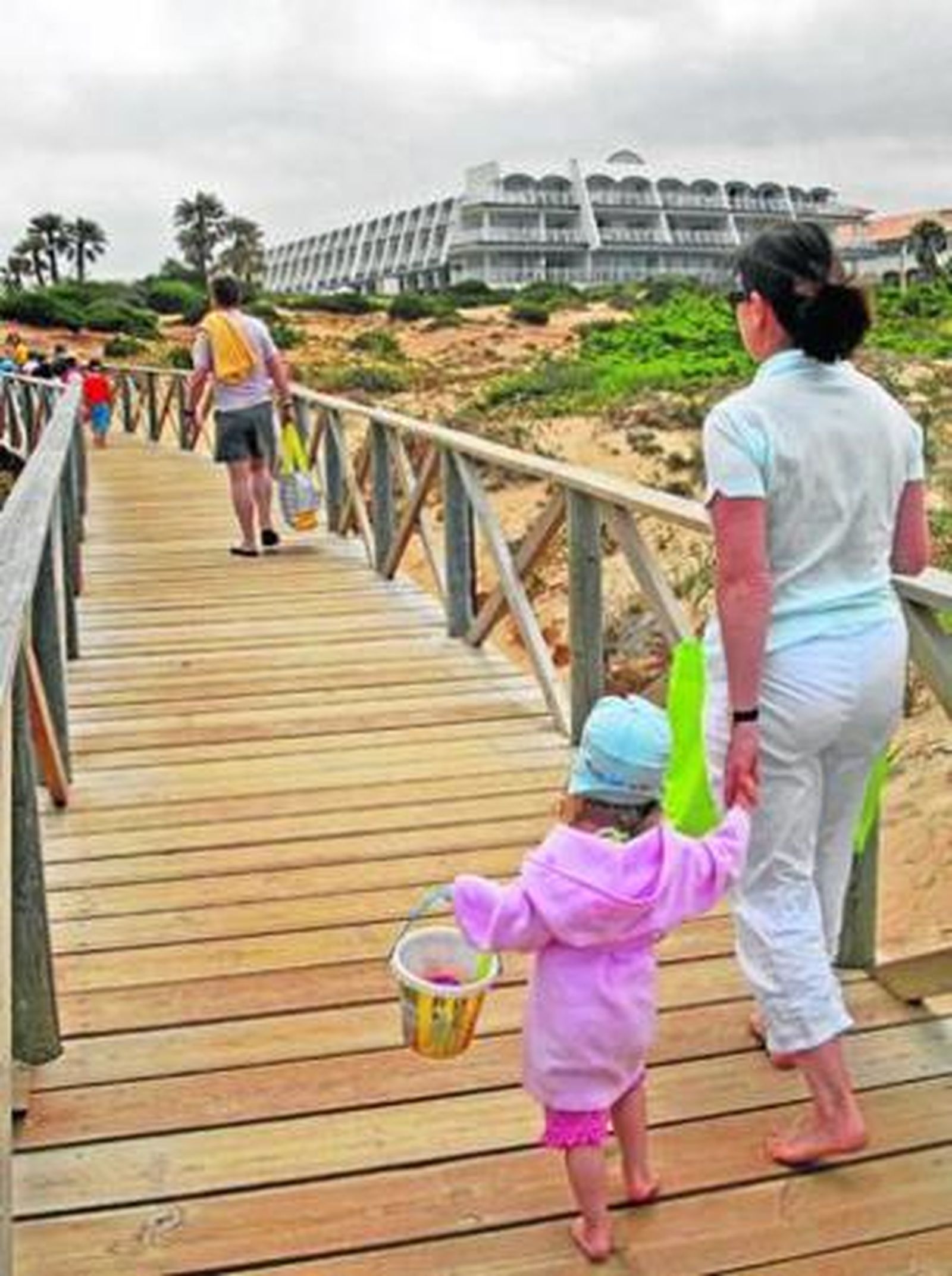 Turistas cruzan una pasarela que conduce a hoteles del Novo Sancti Petri.