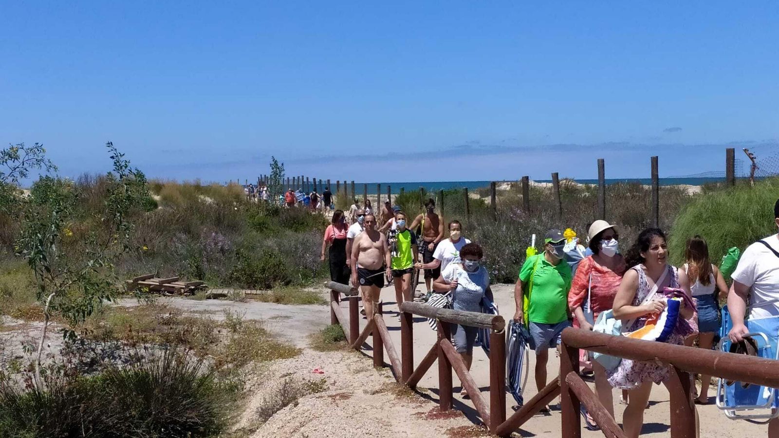 Trasiego de personas en la pasarela de la playa de Camposoto.