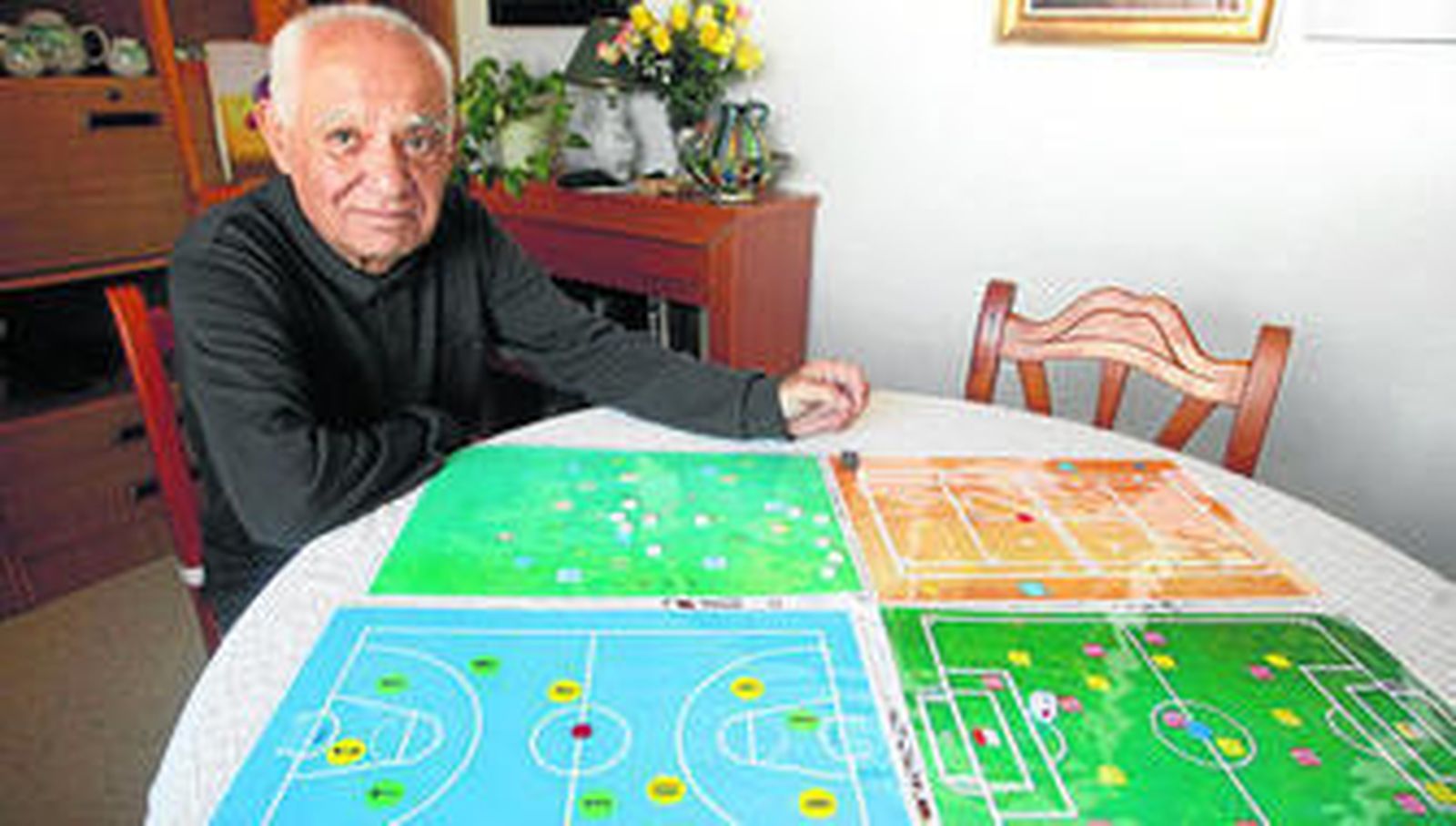 Francisco Vázquez muestra los cuatro tableros de su juego 'Deportes dado'.