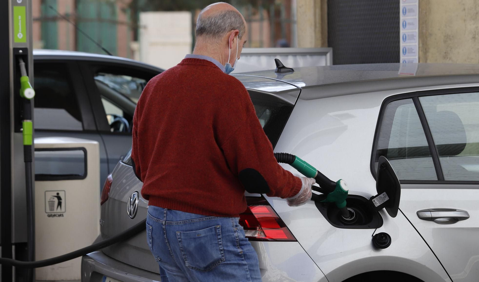 Un hombre echa gasolina en su vehículo.
