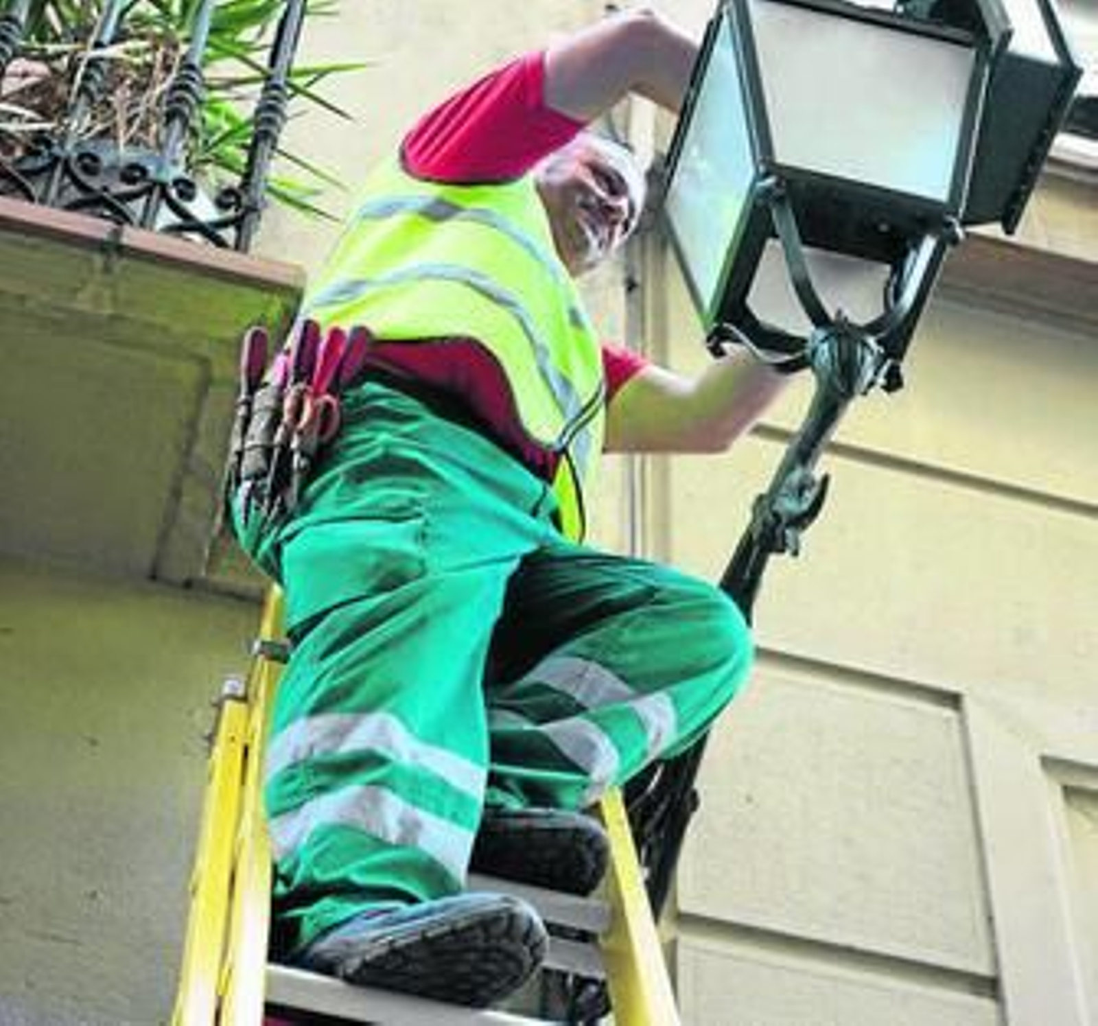 Un operario instala las nuevas lámparas en una de las farolas de la capital.