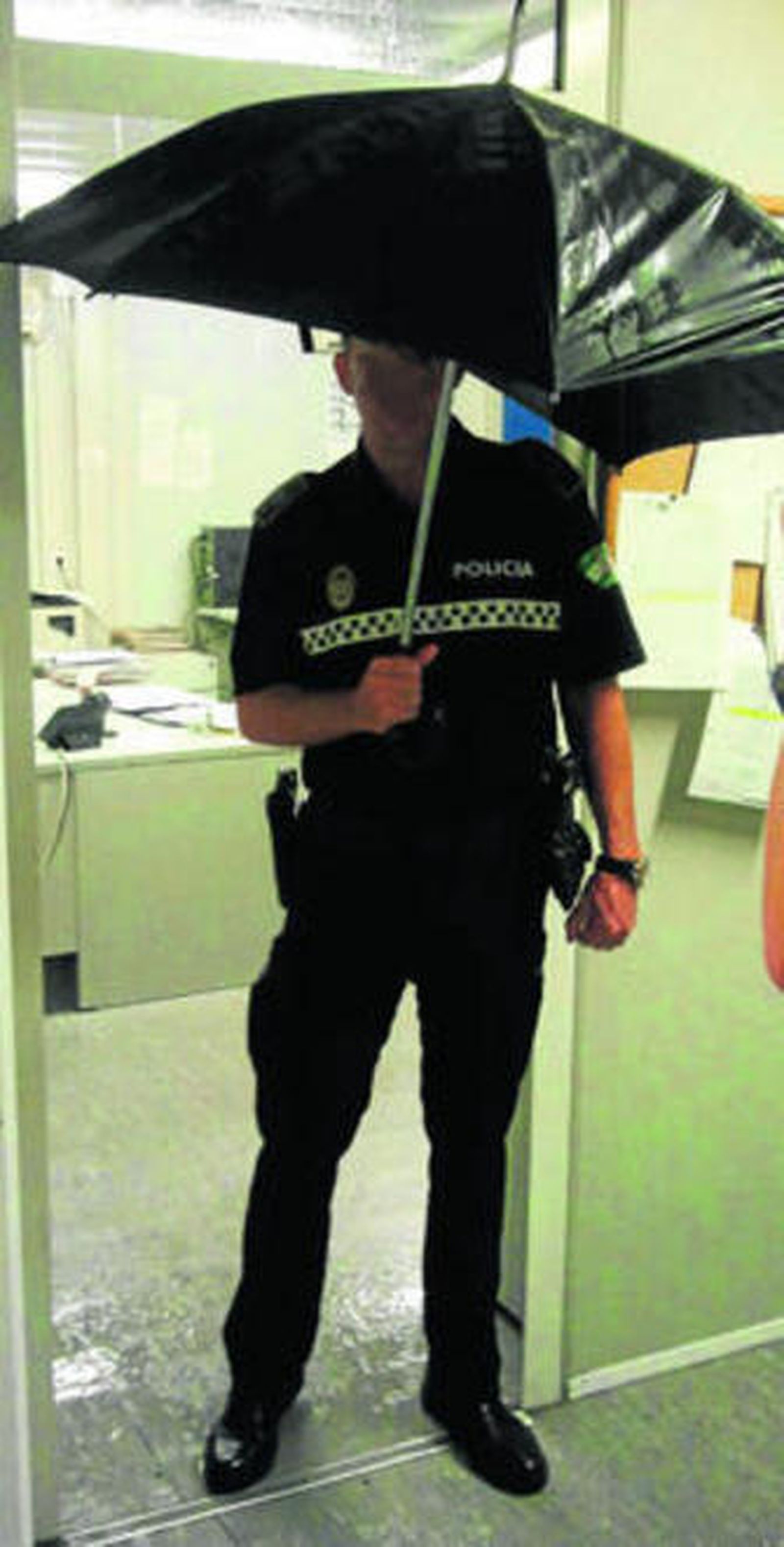 Un policía local se refugia de la lluvia dentro de la comisaría del distrito Sur.