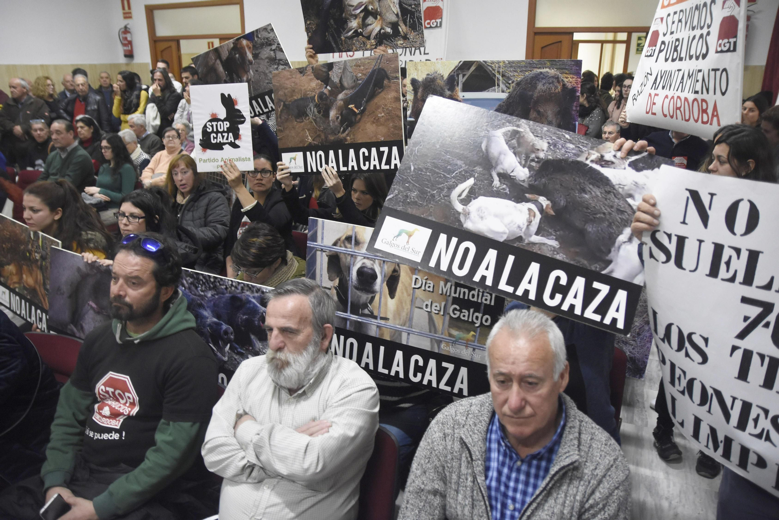 Activistas animalistas y de Pacma protestan contra la moción en defensa de la caza cartel en mano.