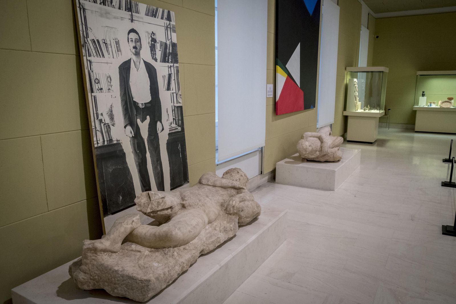 La obra 'Aura' de Pedro G. Romero exhibe sobre la escultura de Los silenos en la sala de Roma el aura de una mujer vestida de hombre. Una sugerente pieza en blanco y negro donde este iconoclasta y mordaz creador plasma una de sus múltiples inquietudes esta vez centrados en el siempre comprometido papel de la mujer.