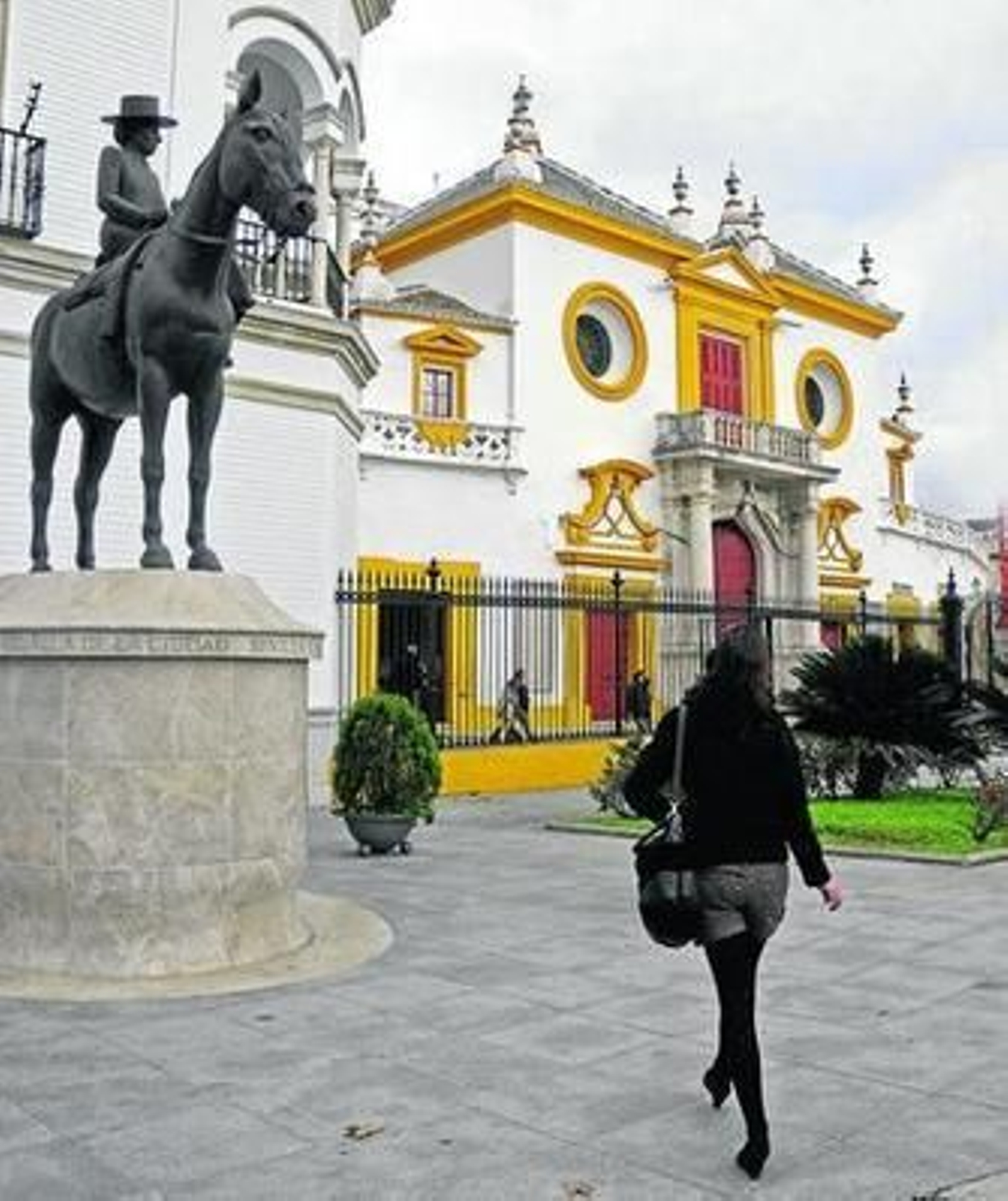 Una turista paseaba ayer junto a la Maestranza, que duerme mientras despiertan las dehesas.
