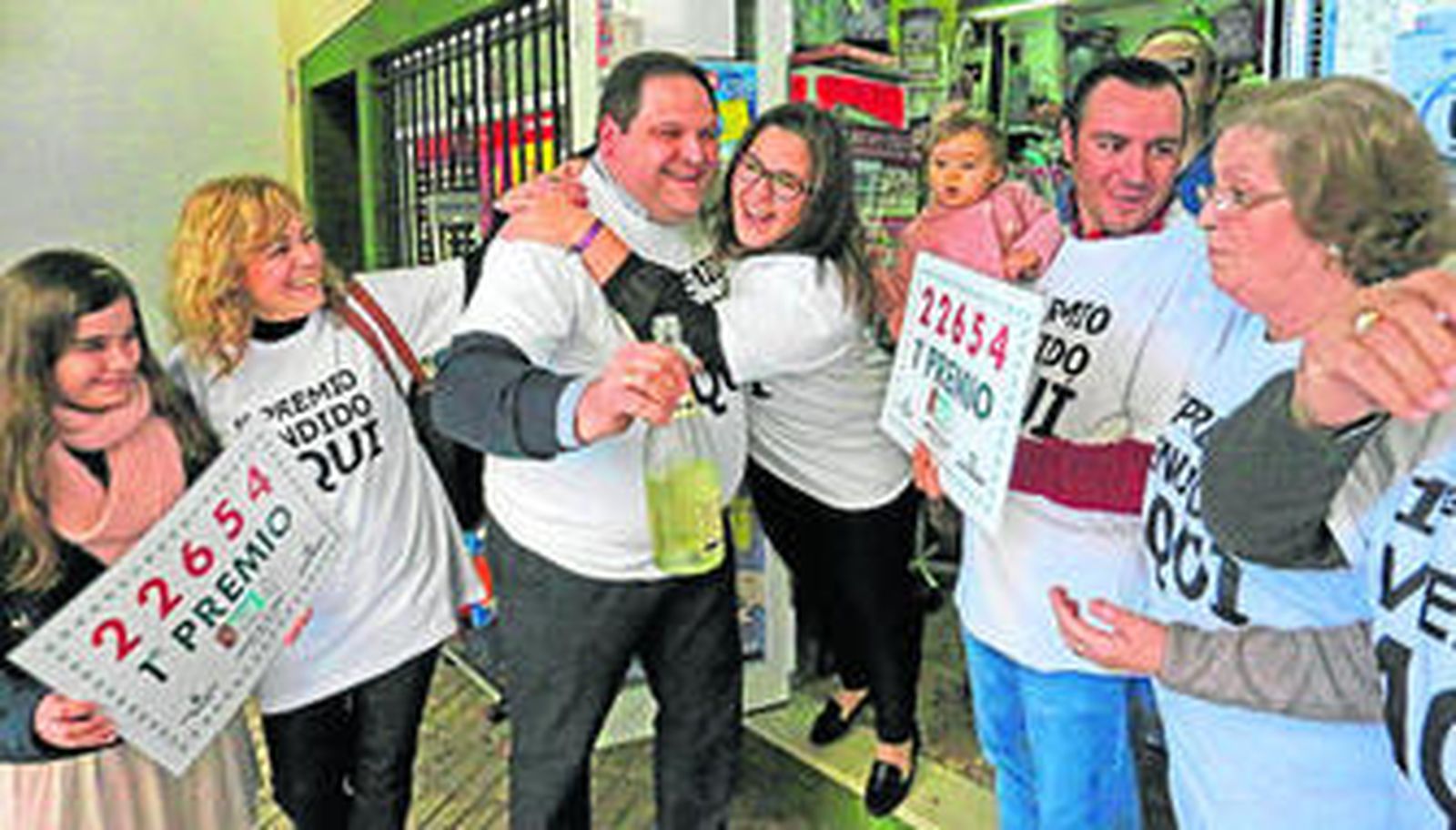 Ángel Ramírez, en el centro, recibe los abrazos de sus familiares y empleados del negocio tras conocerse la noticia.