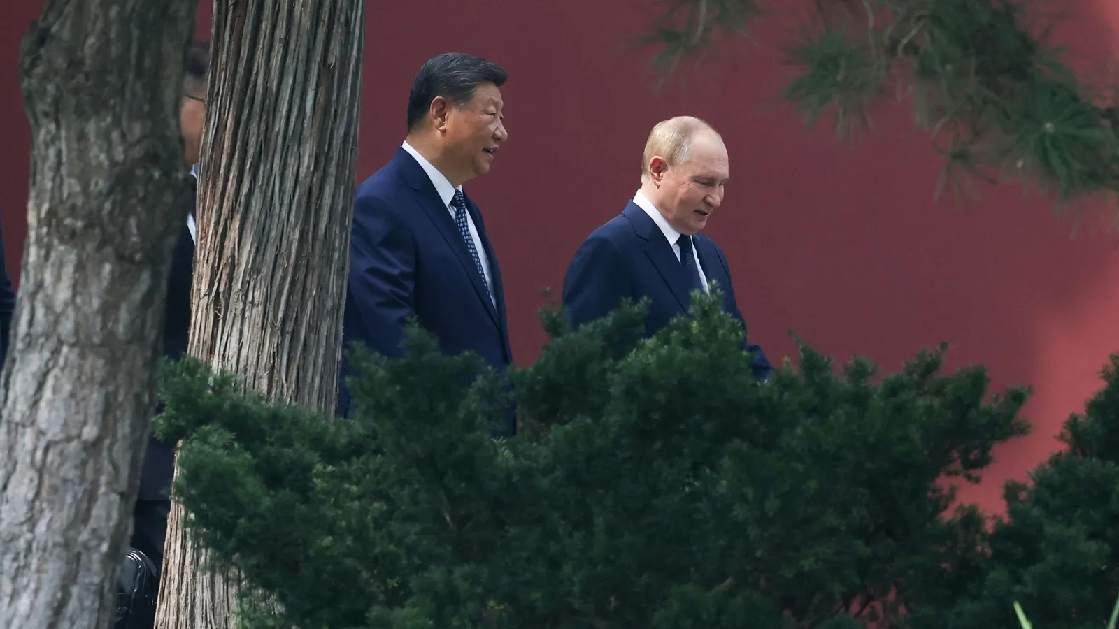 Los presidentes chino, Xi Jinping (izq.), y ruso, Vlamidir Putin, conversan en el jardín de la residencia del primero en Pekín. / Alexander Kazakov (Efe)