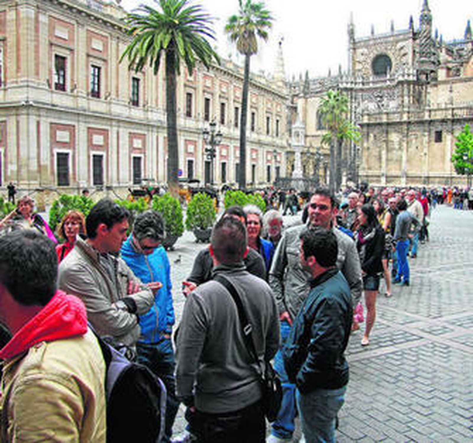 Cola de visitantes para entrar al Alcázar con el Archivo de Indias y la Catedral al fondo.