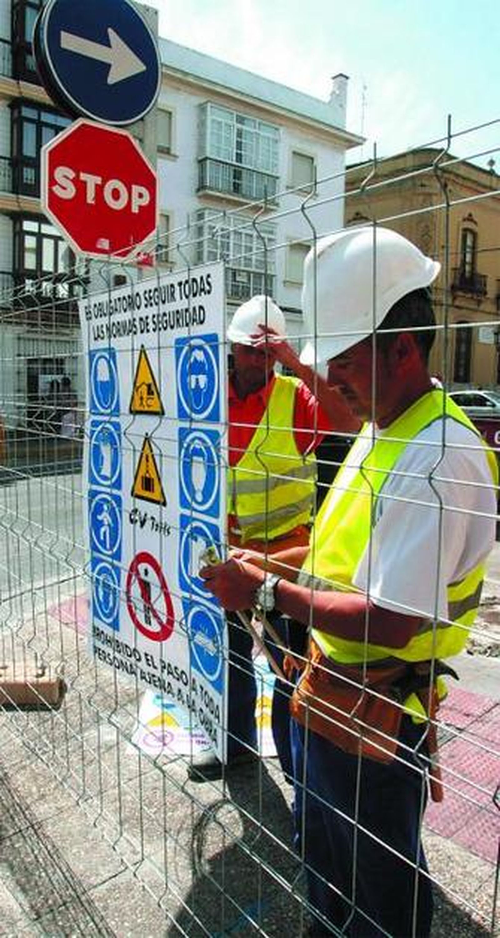 Operarios instalan los carteles de seguridad en la zona en obras.
