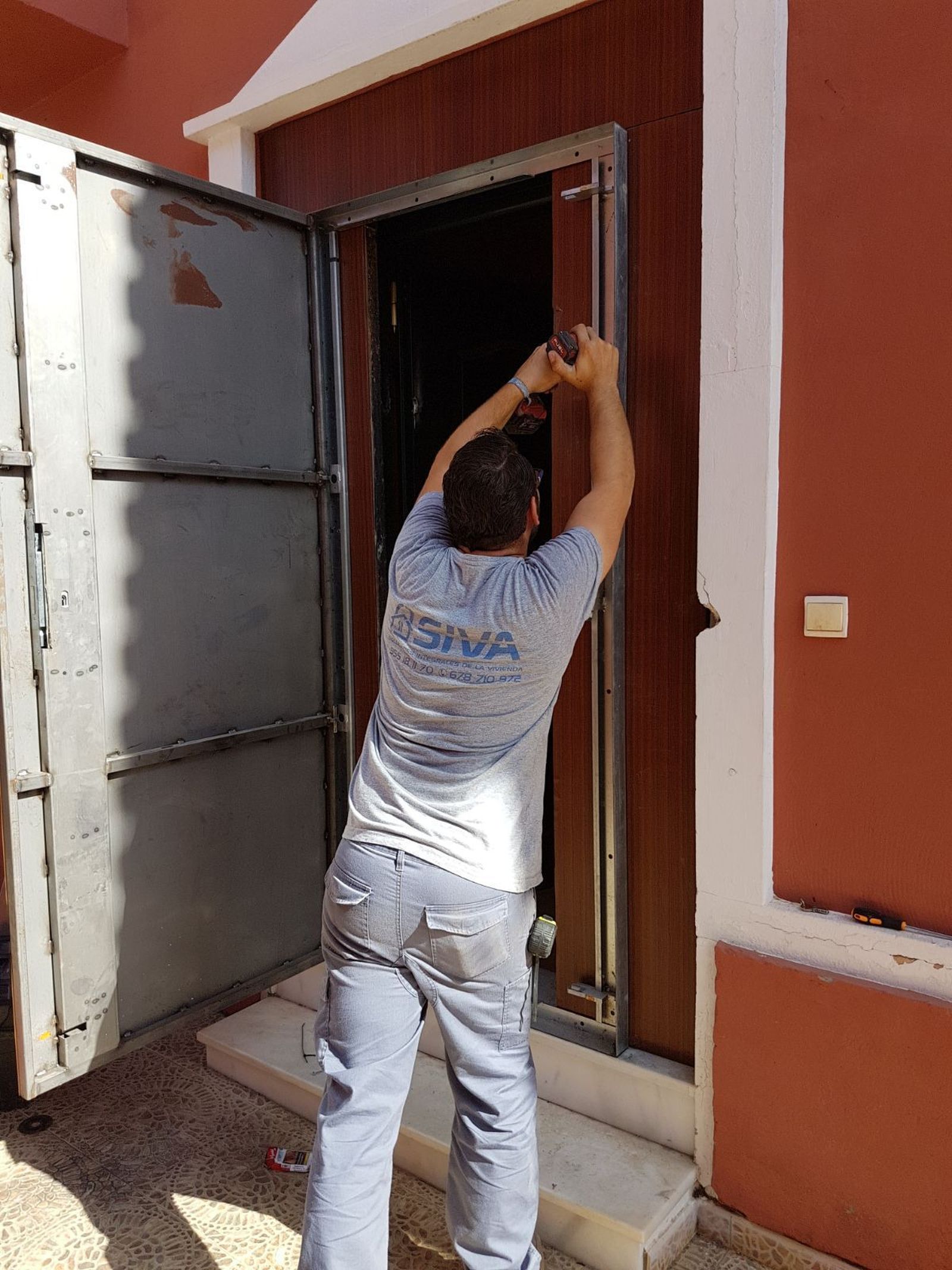 Un operario coloca una puerta anti-okupas