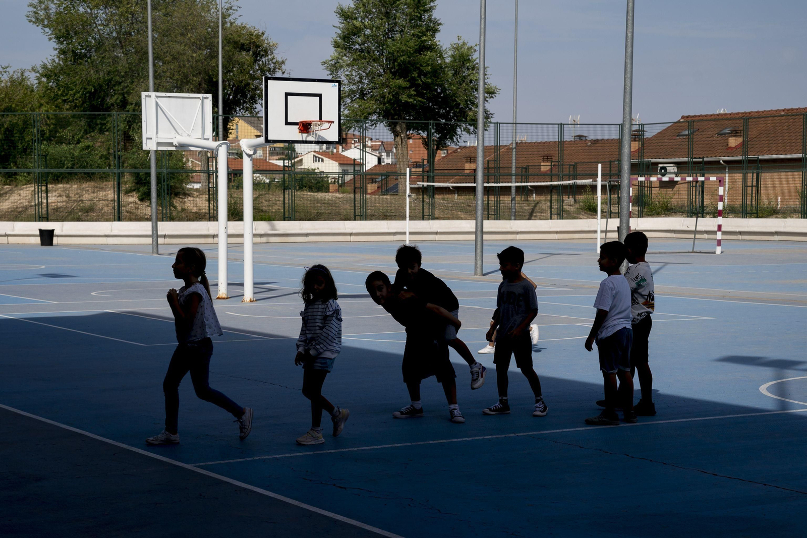 Varios niños juegan en el patio de un colegio.