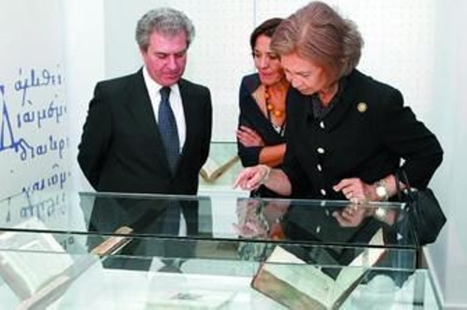 El ministro de Cultura y la Reina observan algunos ejemplares de la muestra.