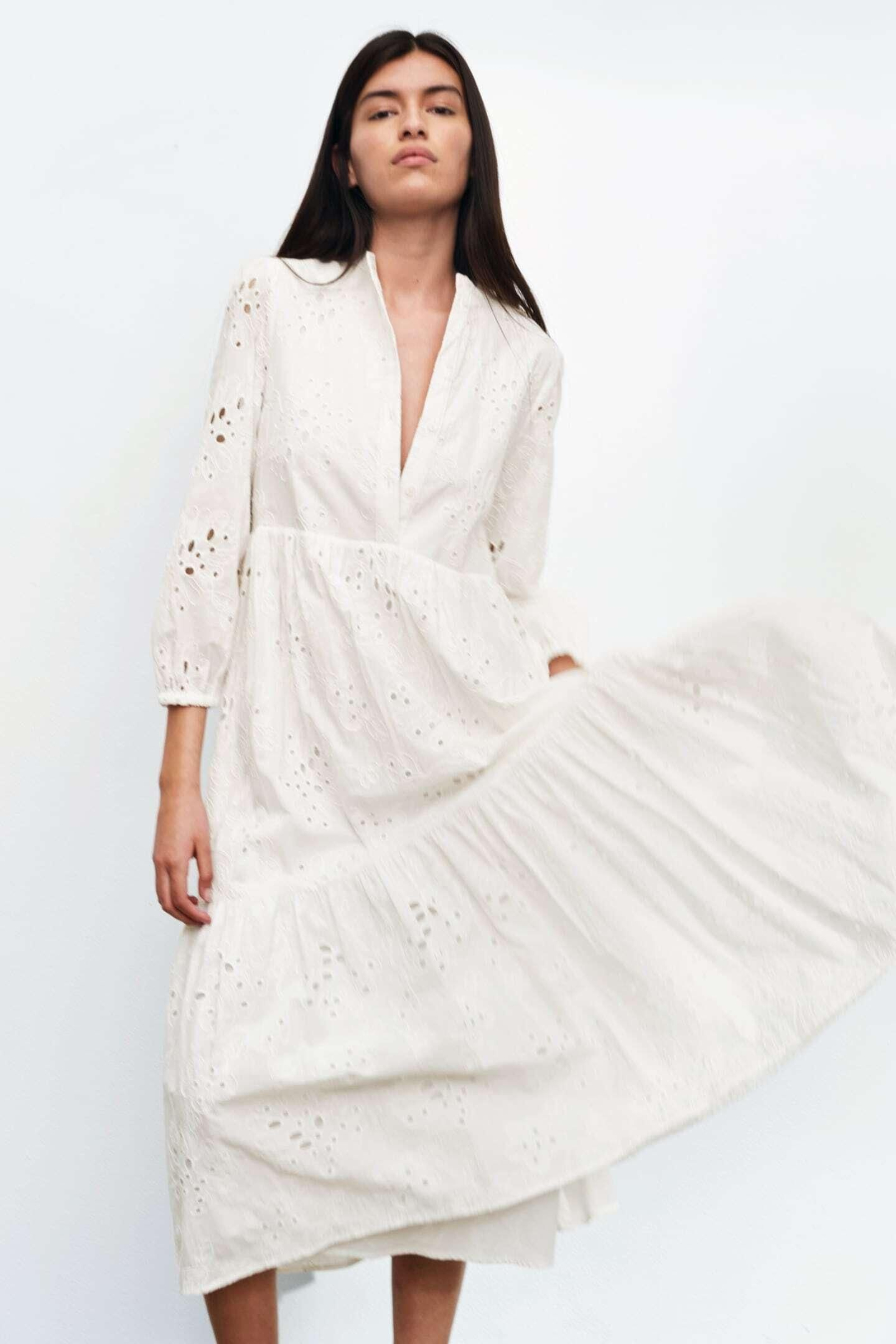 Vestido blanco con bordados y perforado de Zara.