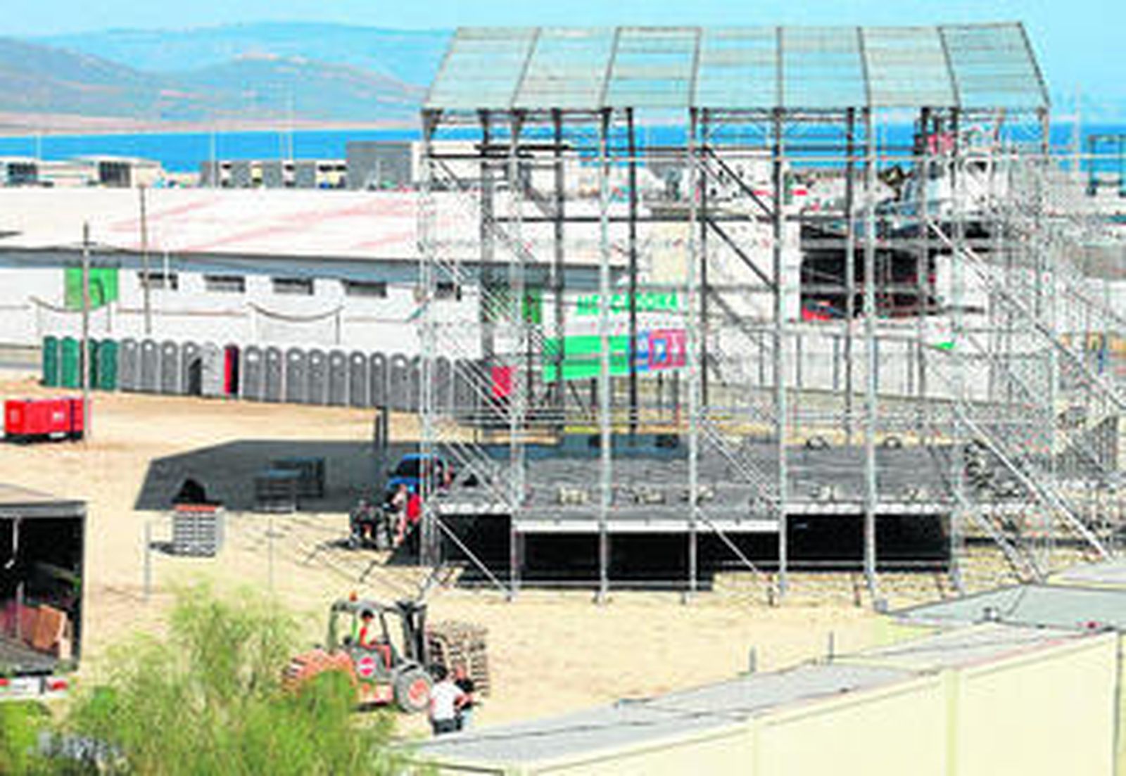 Personal montando el enorme escenario principal (hay otros dos) en el recinto acotado frente al puerto pesquero.