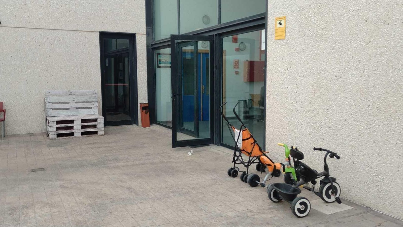 Un triciclo y una sillita de bebé a las puertas del albergue municipal, este viernes.