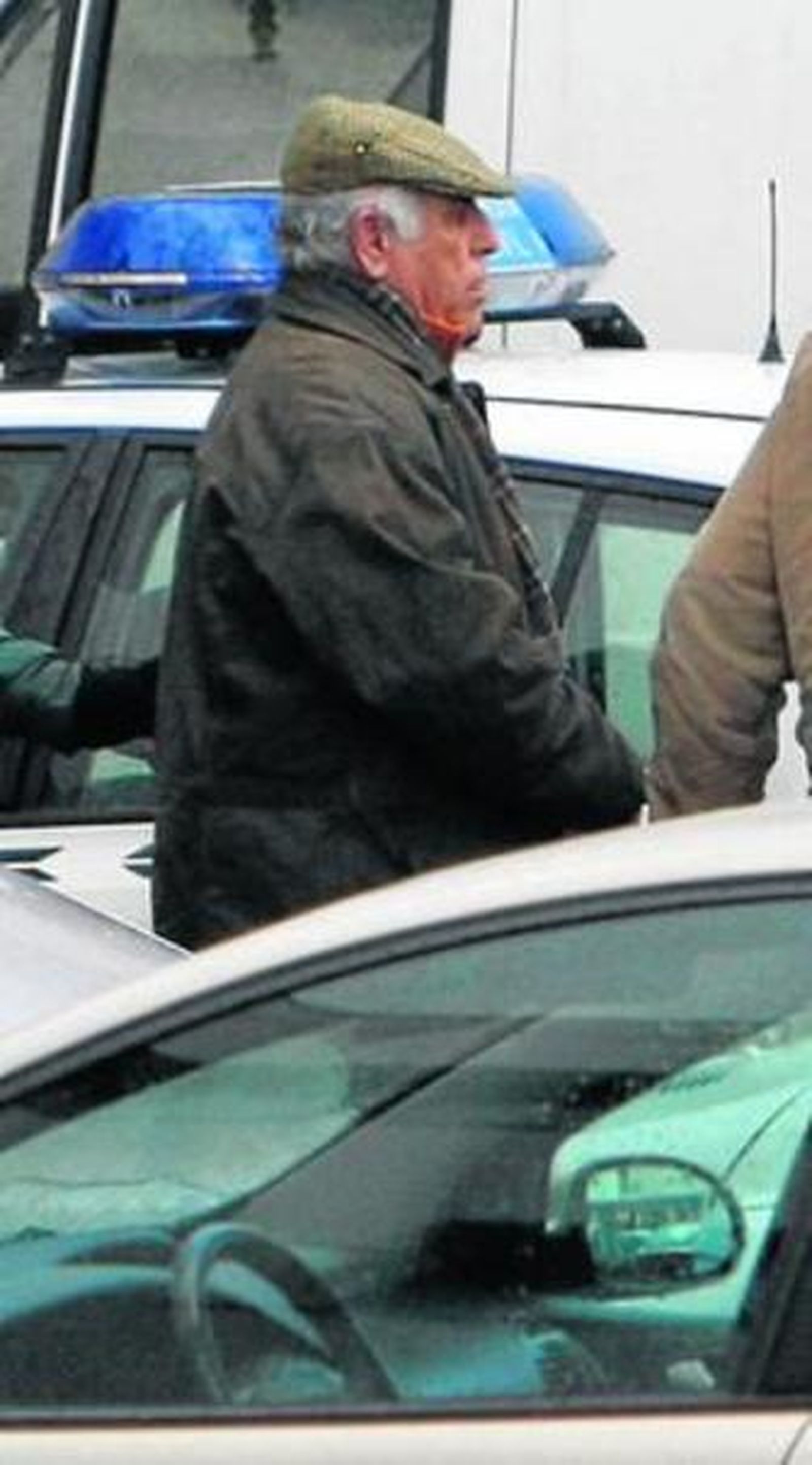 Un agente conduce esposado al patriarca, Juan Galán.