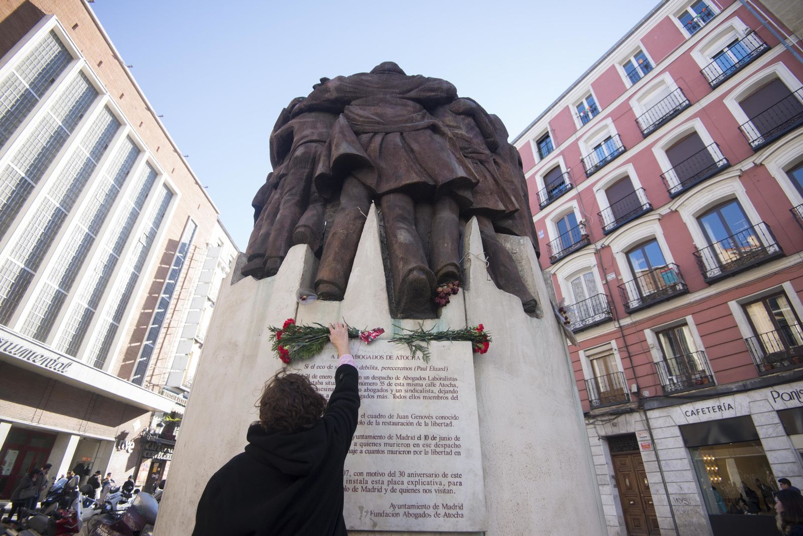 Una mujer colocaba el jueves un ramo de flores en el monumento al crimen de Atocha que esculpió Juan Genovés.