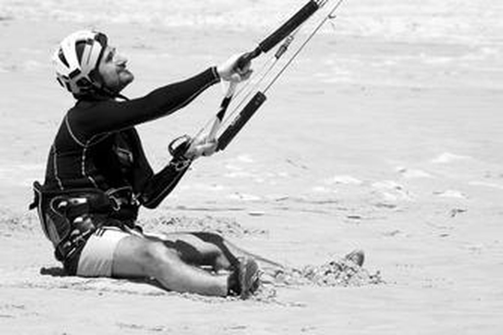 Un hombre, antes de adentrarse en el mar, con una cometa de kitesurf.