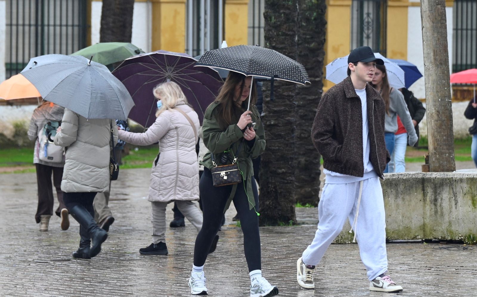 Varias personas paseando bajo la lluvia en Córdoba